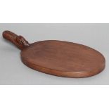 ROBERT THOMPSON, an adzed oak cheeseboard of oval form, the raised handle with carved mouse