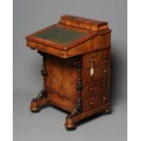 A VICTORIAN WALNUT DAVENPORT, the raised stationery compartment with hinged mildly domed lid, tooled