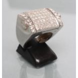 A GENTLEMAN'S DIAMOND "REVERSO" RING, the central oblong panel pave set with numerous small