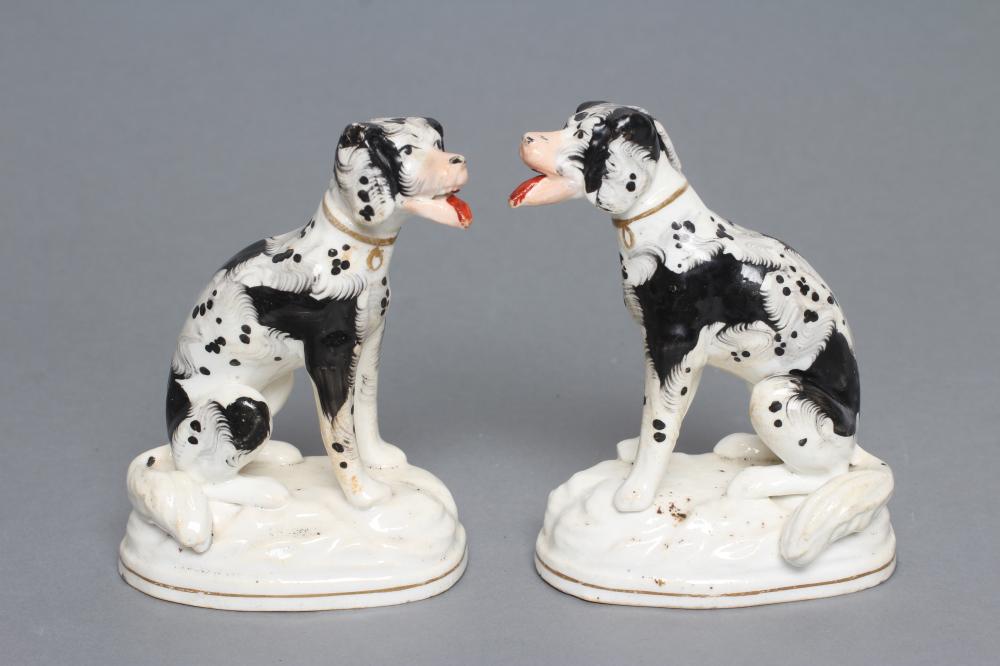 A PAIR OF STAFFORDSHIRE PORCELANEOUS BLACK AND WHITE SPANIELS, c.1830, modelled seated with free