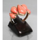 A CORAL DRESS RING, the five tear polished panels collet set to a plain 9ct gold shank, size N (Est.