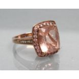 A DRESS RING, the cushion cut pink tourmaline(?) within a border of small similar stones to gem