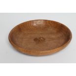 ROBERT THOMPSON, an adzed oak bowl of shallow circular form centred by a carved mouse trademark in