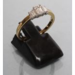 A THREE STONE DIAMOND RING, the three graduated baguettes claw set to a plain 18ct gold shank,