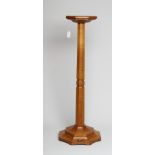 A ROBERT THOMPSON OAK PLANT STAND of octagonal form with collared tapering stem, on flared stepped
