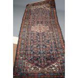 A PERSIAN TRIBAL RUNNER, the navy blue field with repeating floral pattern and centred by an ivory