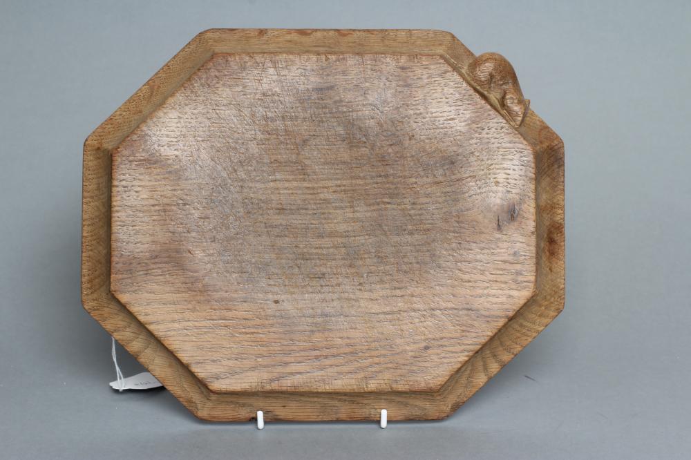 ROBERT THOMPSON, an oak chopping board of canted oblong form, the concave moulded edge with carved