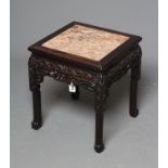 A CHINESE PADOUK WOOD JARDINIERE STAND, c.1900, of square form with inset red marble top, leaf and