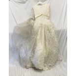 Lace wedding dress. 68cms waist with underskirts and a veiled head dress with wax flowers. Condition