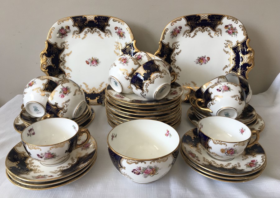 A Coalport tea service, 12 saucers, 12 plates, 12 cups, 1 sugar bowl and 2 cake plates. Condition