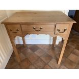 A pine side table, three drawers to front with shaped frieze. 75 w x 49.5 d x 72cms h. Condition