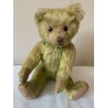 Vintage straw filled teddy. Faded lime green with brown stitched nose and felt pads to paws.