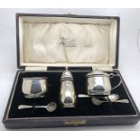 Boxed hallmarked silver cruet set with blue glass liners, Birmingham 1932.