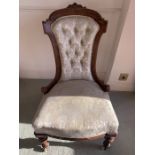 A mid 19thC upholstered nursing chair on turned front legs and castors, upholstered in cream damask.
