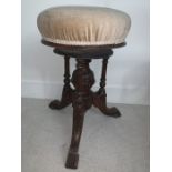 A 19thC piano stool with circular revolving top. Central carved pillar with 3 surrounding turned