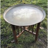 Indian brass tray topped folding table. Oak base, 58cms w tray, 50cms h. Condition ReportGood