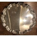 A silver tray with shaped edge raised on 3 scrolled feet, Sheffield 1997, 25cms d, 481.94gms.