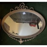 Oval gilt framed wall mirror. 39 x 75cms. Decorative bow to top and swag to base.Condition