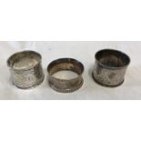 Three hallmarked silver napkin rings, Chester, pair, R.G. date mark indistinct, engraved cartouche