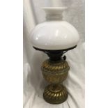A Victorian brass oil lamp with milk glass shade, 43cms h with chimney flute. Condition