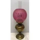 Brass oil lamp with acid etched cranberry colour glass shade, 52cms h to inner chimney top.