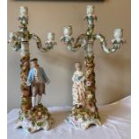 Two 19thC candelabra 54cms h . Male and female with three scroll branches on decorated foliated
