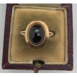 A 9ct gold dress ring set with dark red stone, size P. 3.1gms.Condition ReportSurface scratches to