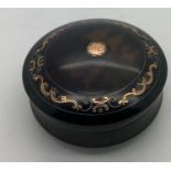 A tortoiseshell piquee lidded box. 6cms d.Condition ReportGood condition.
