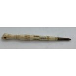 A 19thC bone handled pencil with clenched fist to the top 11cms, containing a Stanhope, a souvenir