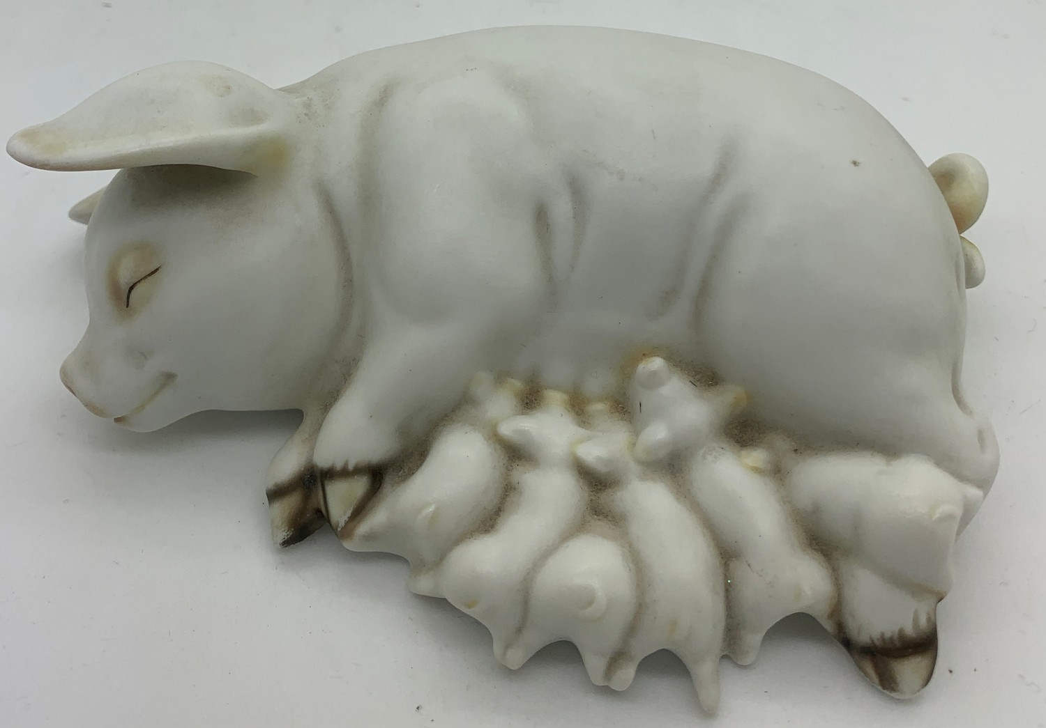 A ceramic recumbent pig suckling piglets. 15cms l.Condition ReportGood condition.