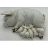 A ceramic recumbent pig suckling piglets. 15cms l.Condition ReportGood condition.