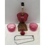 Cranberry glass electrified oil lamp with cast iron base 39 cm H, two cranberry bowls 11.5 cm w