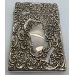 A hallmarked silver card case with repouse decoration and vacant cartouches. Birmingham 1902. 10 x