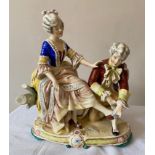 A continental porcelain figurine of a seated lady and a kneeling gentleman. 30cms h x 26cms w at