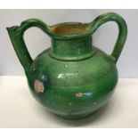 A green glazed pottery two handled jug from Provence circa 1850 approx. 21cms h x 24cms w.