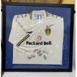 A framed Leeds United football shirt with signatures to include Lucas Radebe and others.Condition