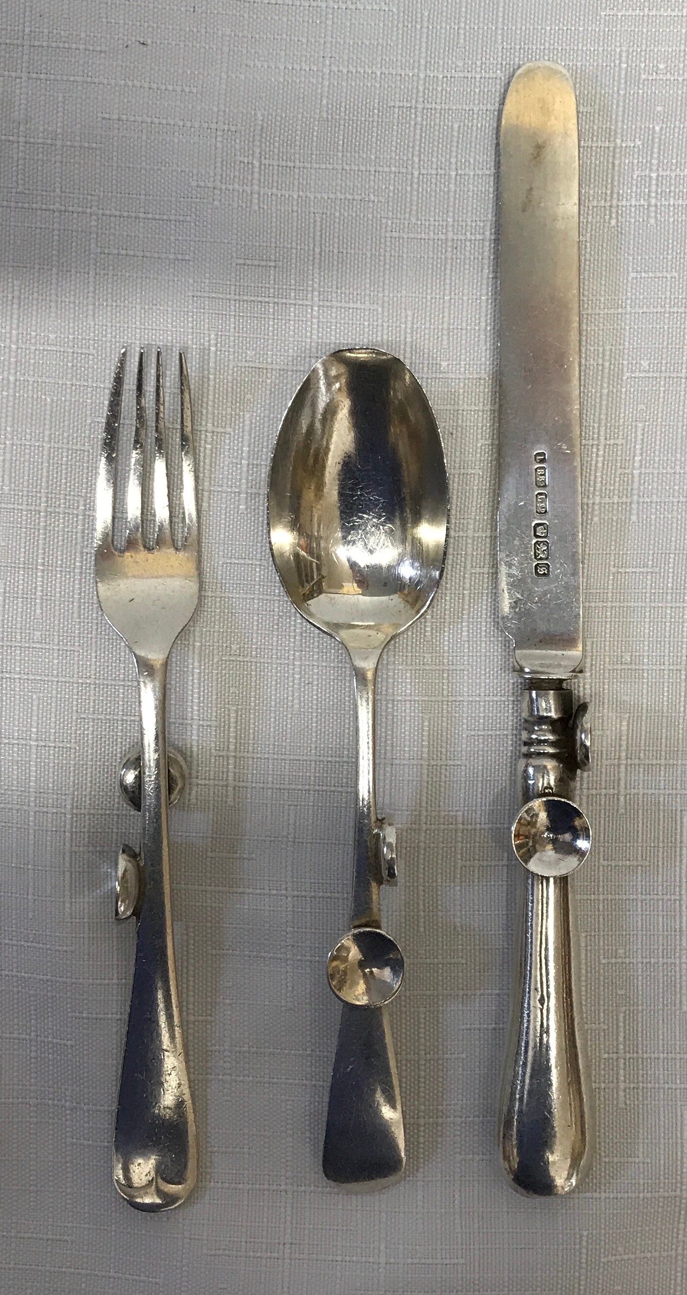 A Silver cutlery set, Sheffield 1910 L BRS Ltd with ergonomic design possibly for infants due to