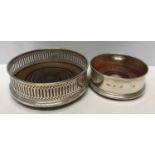 Two hallmarked silver coasters with mahogany bases. One by W. W. London 1986 13cms d, the other by