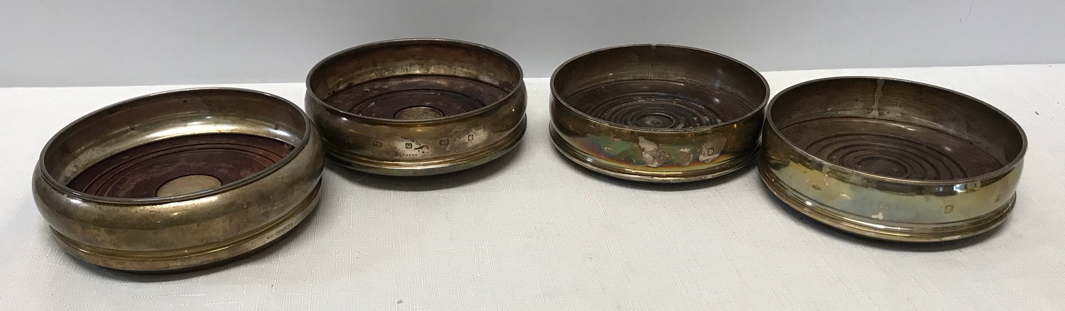 Four silver mounted bottle coasters with mahogany bases. One pair DRM London 1990, one B and Co