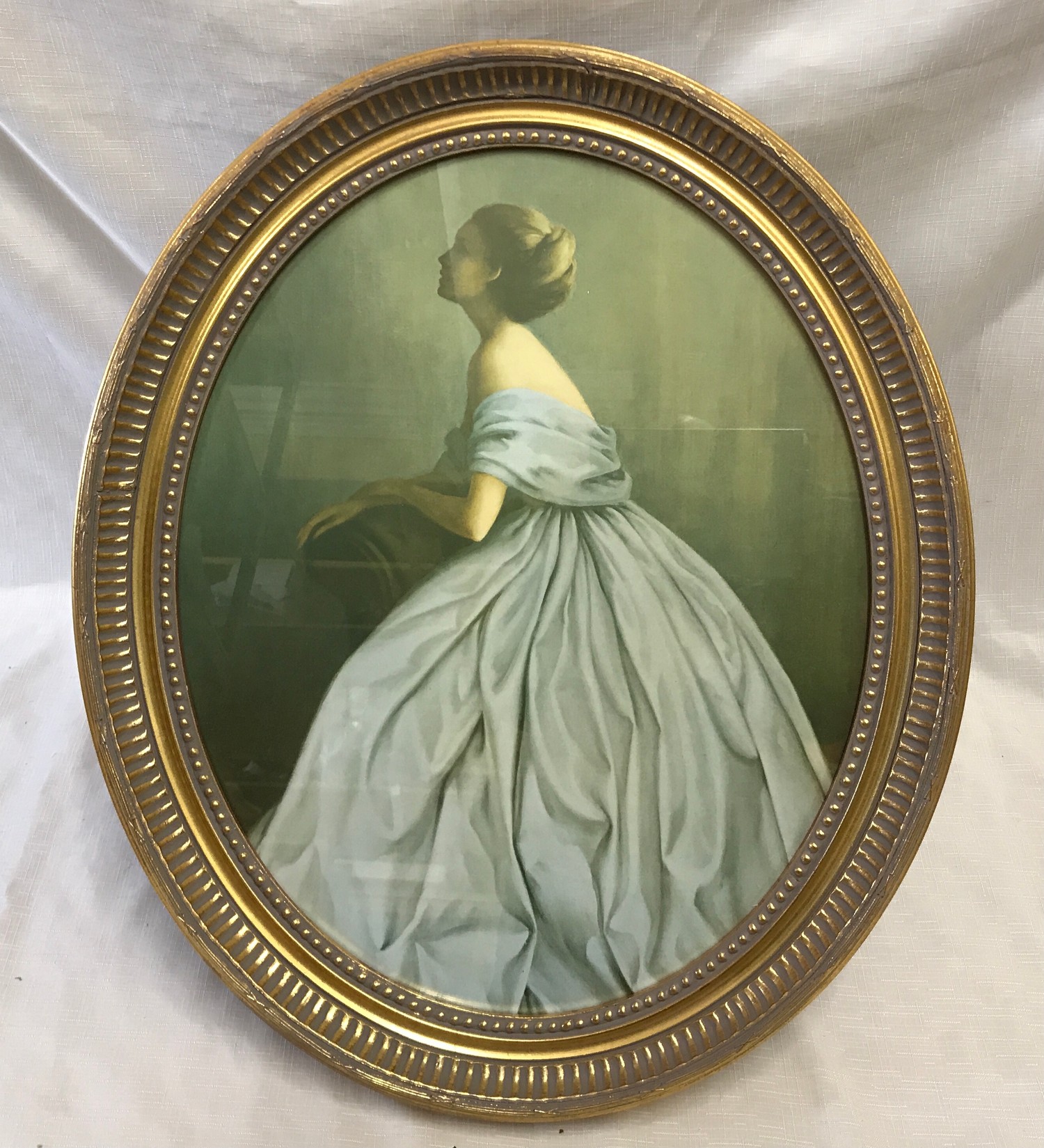 Oval gilt framed print. Portrait of a lady in a blue dress. Print size 39cm x 49cm.Condition