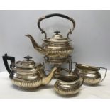 A three piece silver plated tea set with a matching spirit burner kettle and stand. Ebony handles