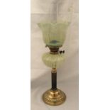 A Victorian vaseline glass oil lamp with a floral pattern shade and wood corintheum column on a