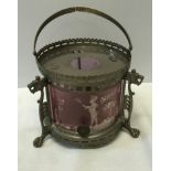 A small metal oil lamp with Mary Gregory pink shade on a stand with three lion's heads with clawed