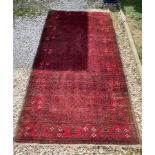 A red ground wool rug with a Persian pattern. Approx. 112cms x 216cms.Condition ReportSmall