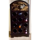 A Chinese black lacquer wine rack with ornately decorated panels to sides and top with cherry