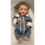 A small pot headed doll with composite body and open/close eyes. A number stamp to the back of the