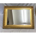 Large decorative gilt framed bevel edged wall mirror. Mirror size 70cm x 47cm. Frame size 91cm x