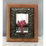 An embossed silver plate framed wall mirror with a velvet lined back with a cranberry glass flute to