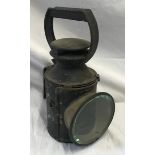 An early painted metal railway oil lamp with burner inside, 29cms to the handle, glass width 11cms.