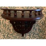 A 20thC mahogany wall shelf with decorative carving and gallery top. 36 w x 40cms h.